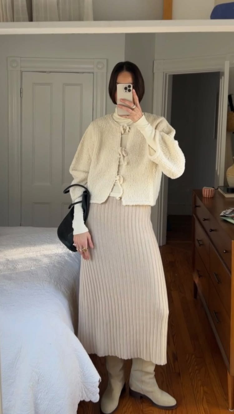 Woman wearing a cream cardigan and a long beige ribbed knit maxi skirt.