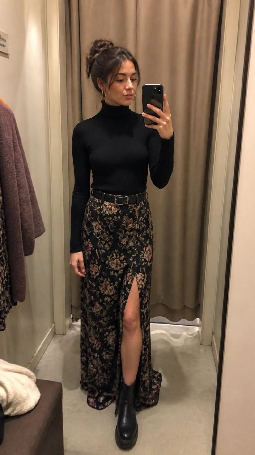 Woman in a black turtleneck and floral maxi skirt posing in a mirror selfie.