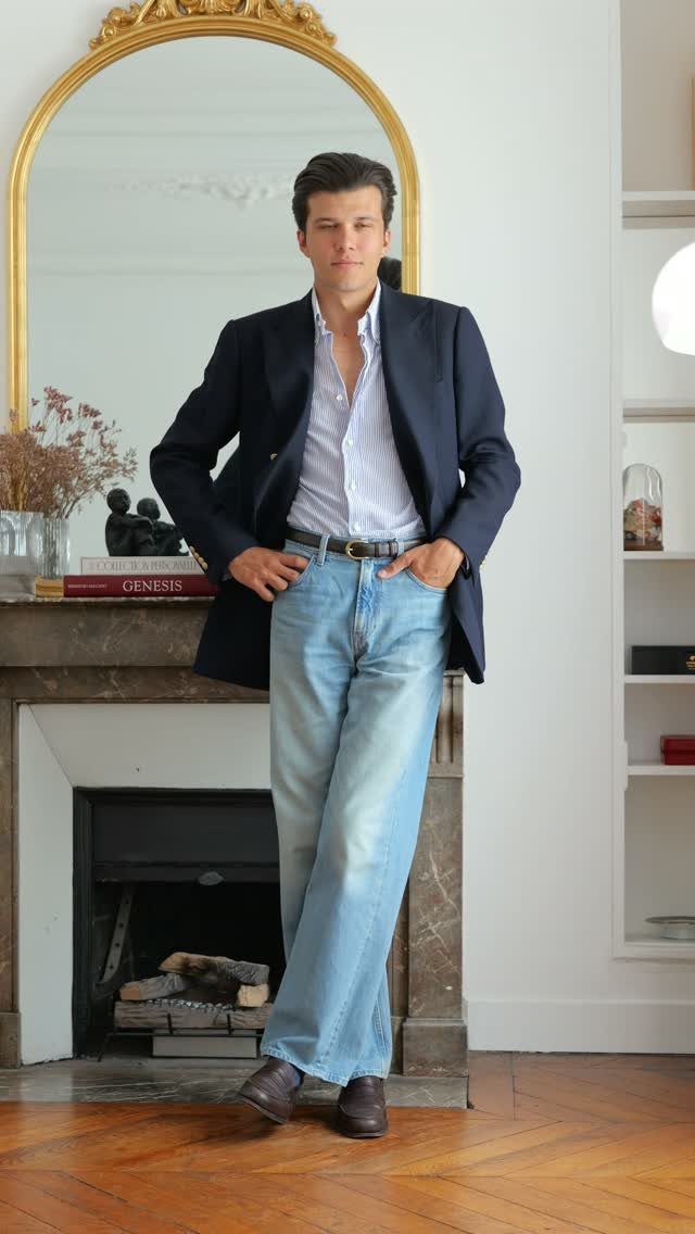 A man in light blue jeans, a navy blazer, and brown leather dress shoes.