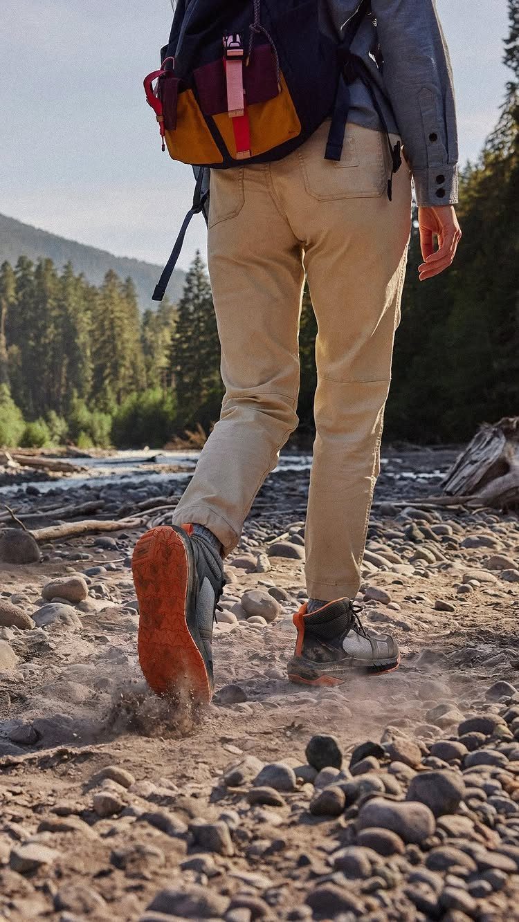 Person walking on a rocky terrain wearing hiking boots and a backpack.