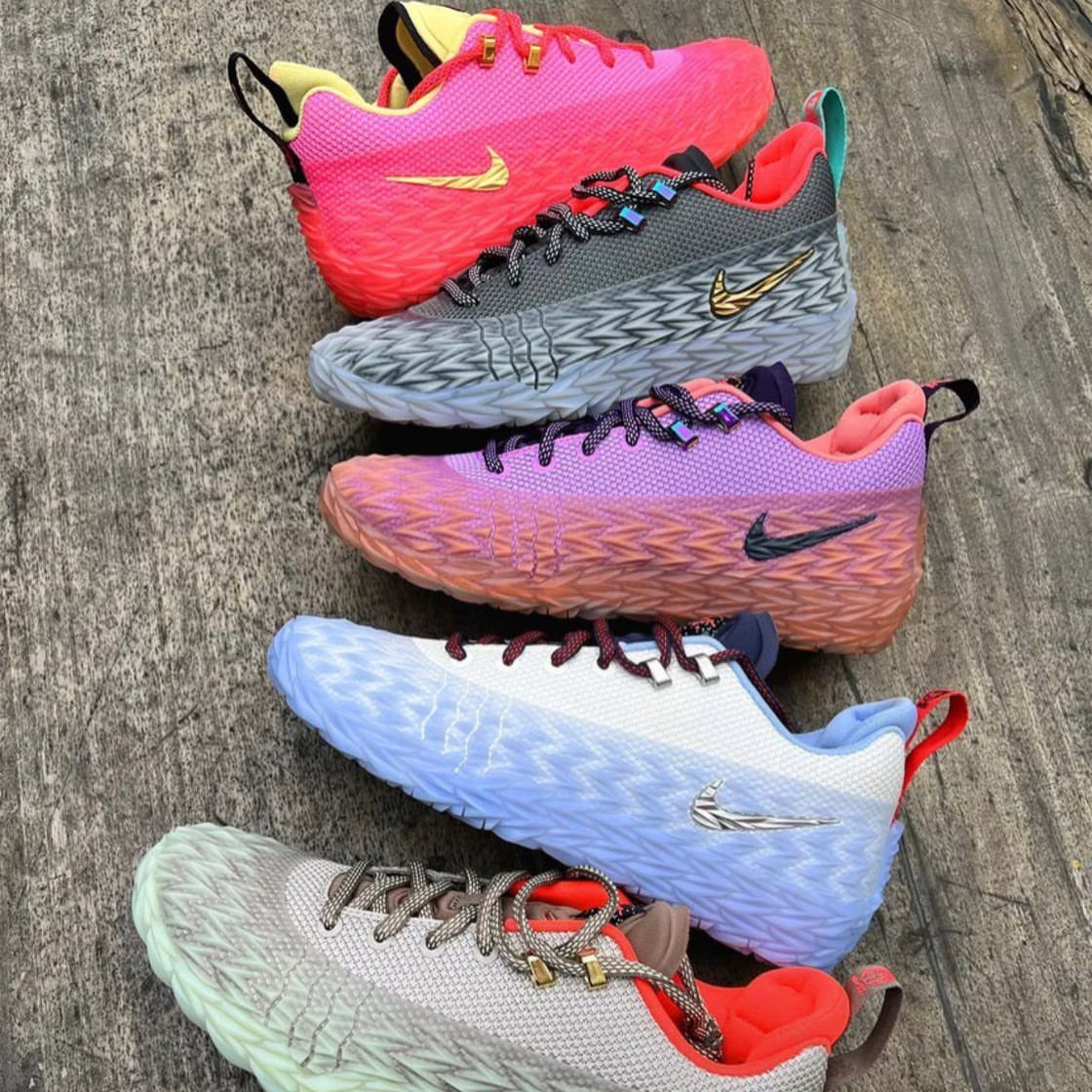 Five colorful Nike performance sneakers arranged diagonally on a rustic wooden surface.