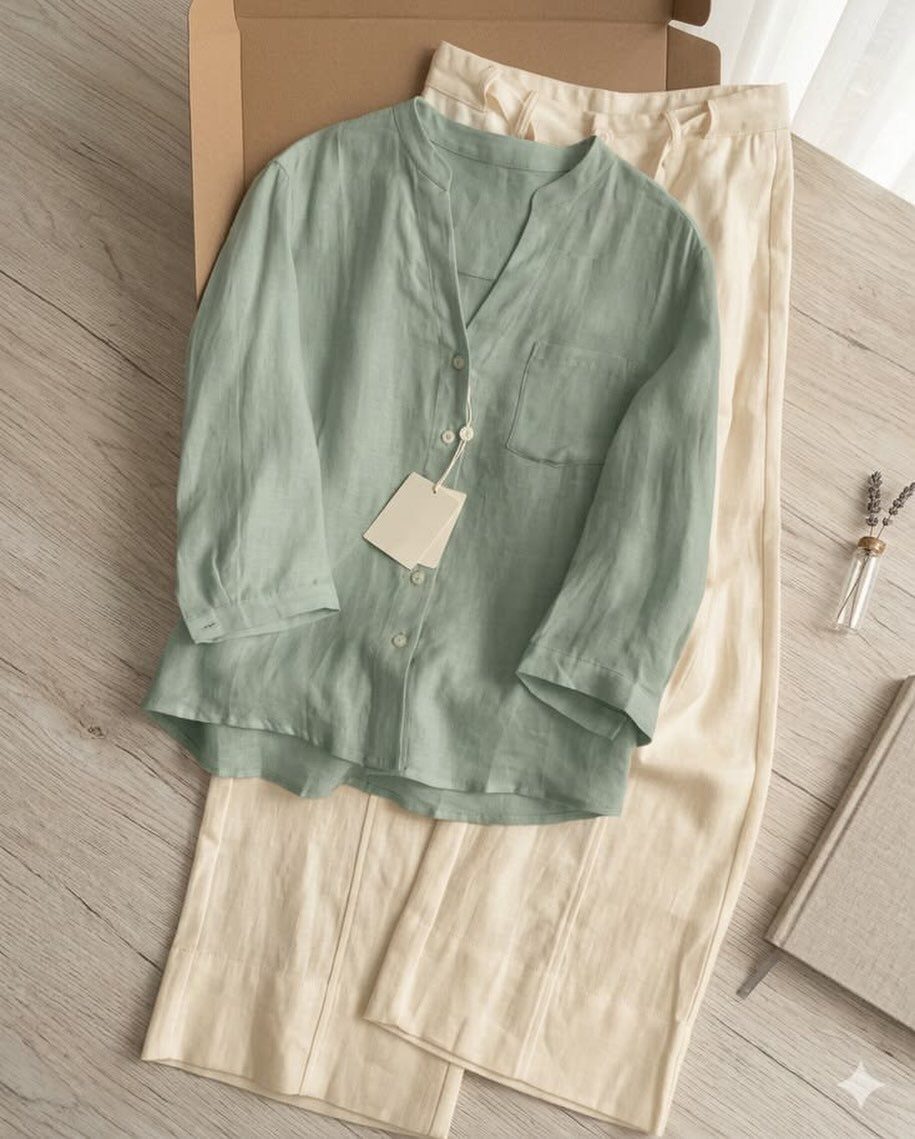 Light green linen shirt and cream linen trousers arranged inside a cardboard box.
