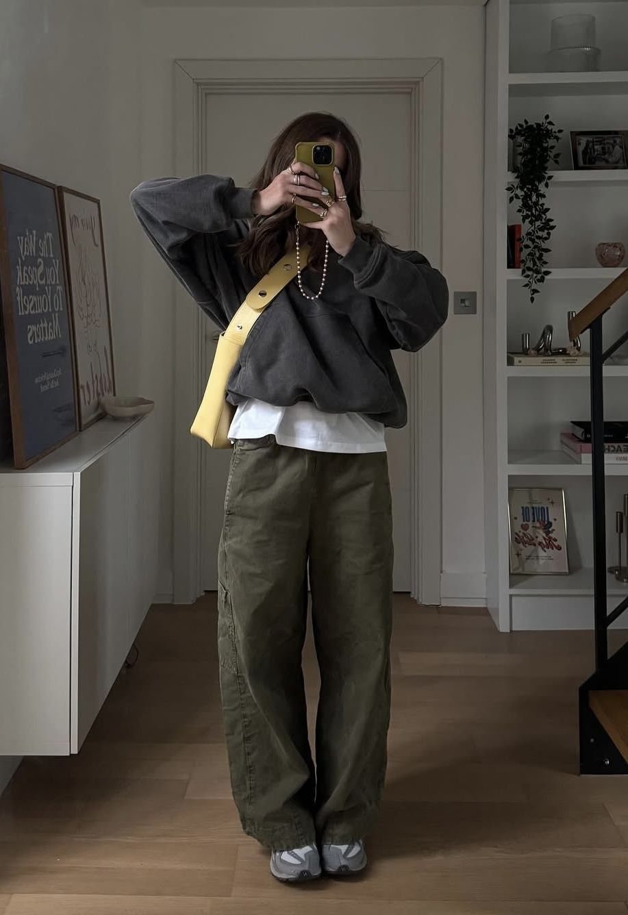 Person wearing olive green wide-leg pants, a grey sweatshirt, and light blue sneakers.