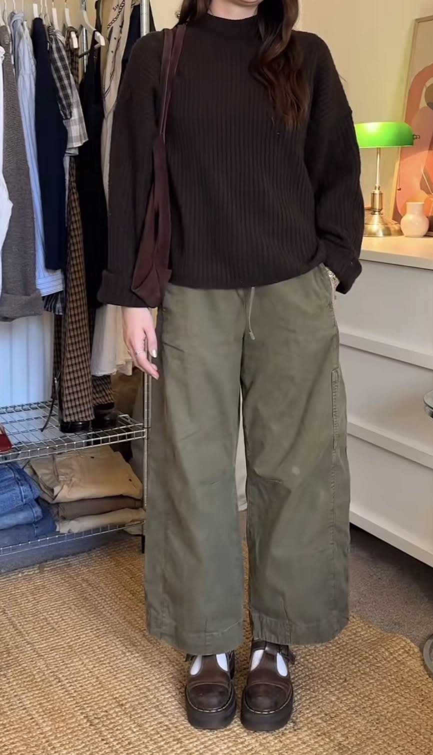 Person wearing a brown ribbed sweater, olive green wide-leg pants, and dark brown platform shoes.