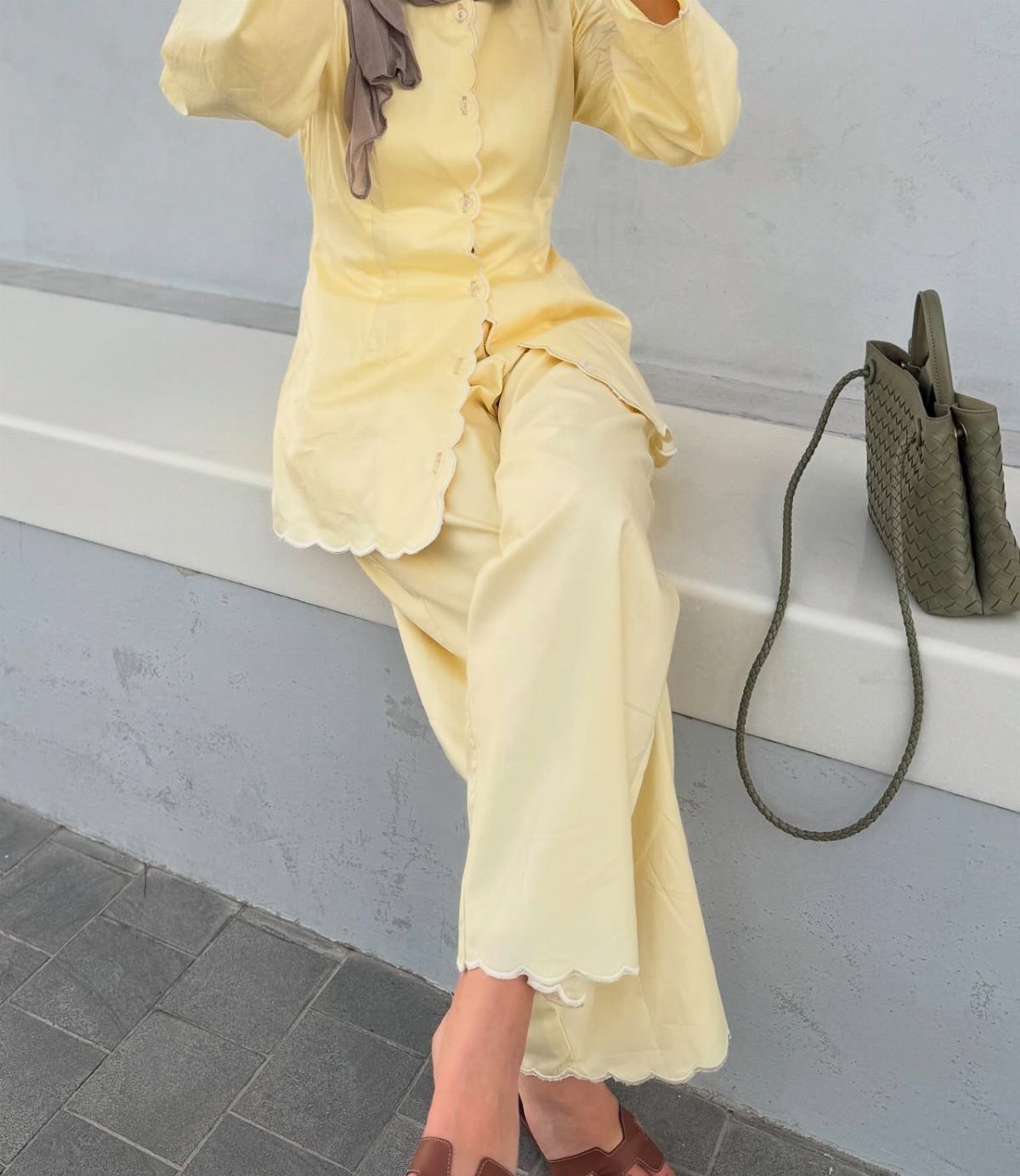 Person wearing a pale yellow matching co-ord set with scalloped edges and wide-leg trousers.